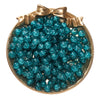 A round gold-toned dish filled with bright teal blue glass crackle beads for jewelry making