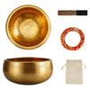 A set of handcrafted brass singing bowls, including a large bowl and a wooden mallet, with a red patterned ring and a beige c