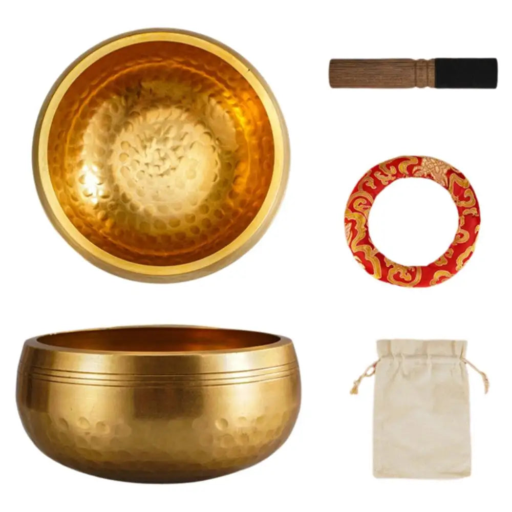A set of handcrafted brass singing bowls, including a large bowl and a wooden mallet, with a red patterned ring and a beige c
