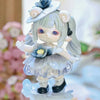 A light blue collectible figurine of a girl with silver hair and blue accents, featuring a layered dress and a wide-brimmed h