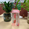 A box of Nice Cube stress relief ice cubes with a watermelon theme next to a potted green plant.