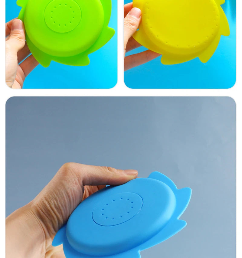 A hand holds a blue silicone splash flying ring toy for water play.