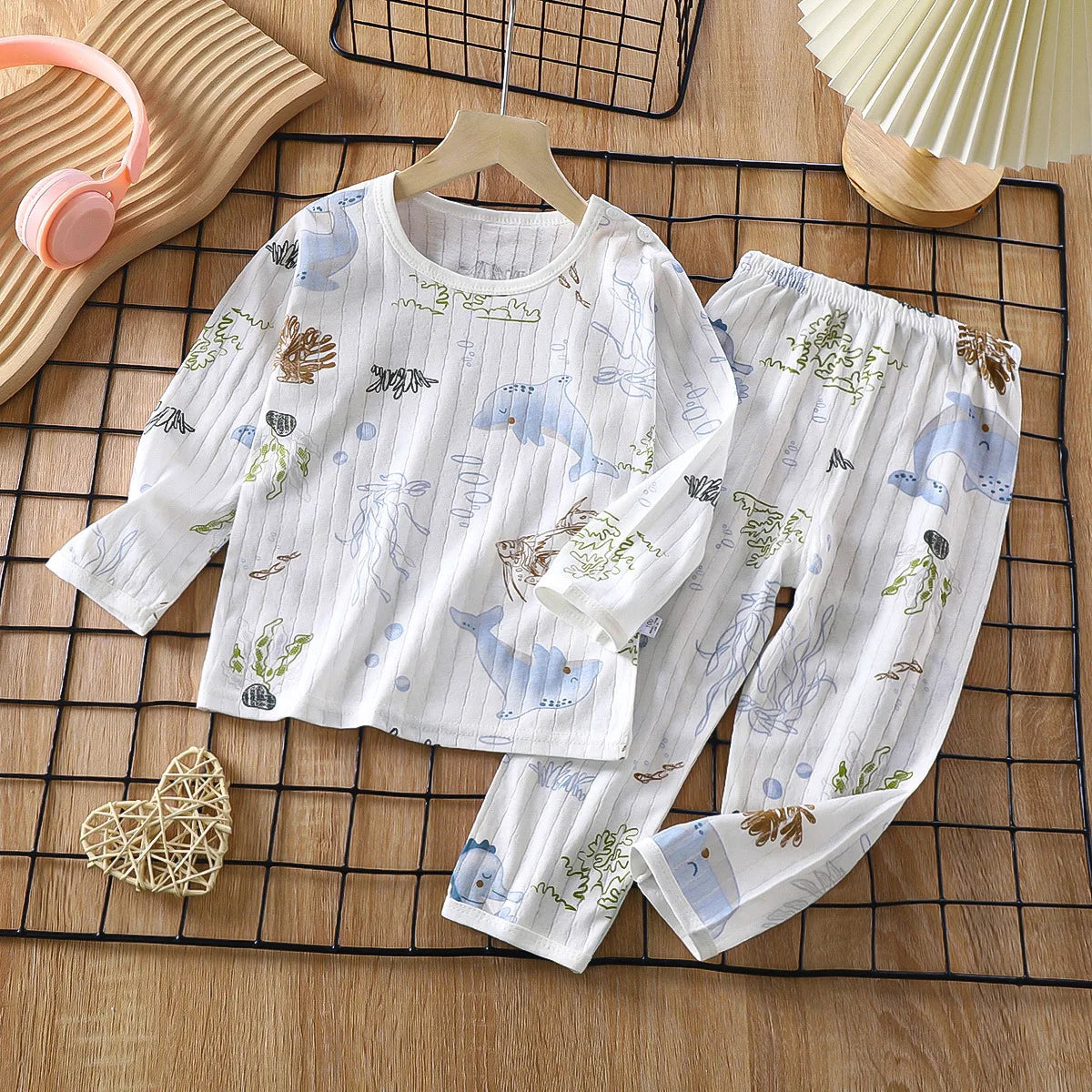 White cotton pajama set for kids featuring a light blue watercolor pattern of marine life and foliage