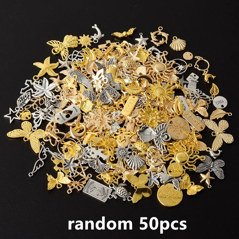 A pile of random mixed metal charms including stars, leaves, and various decorative elements for DIY jewelry making