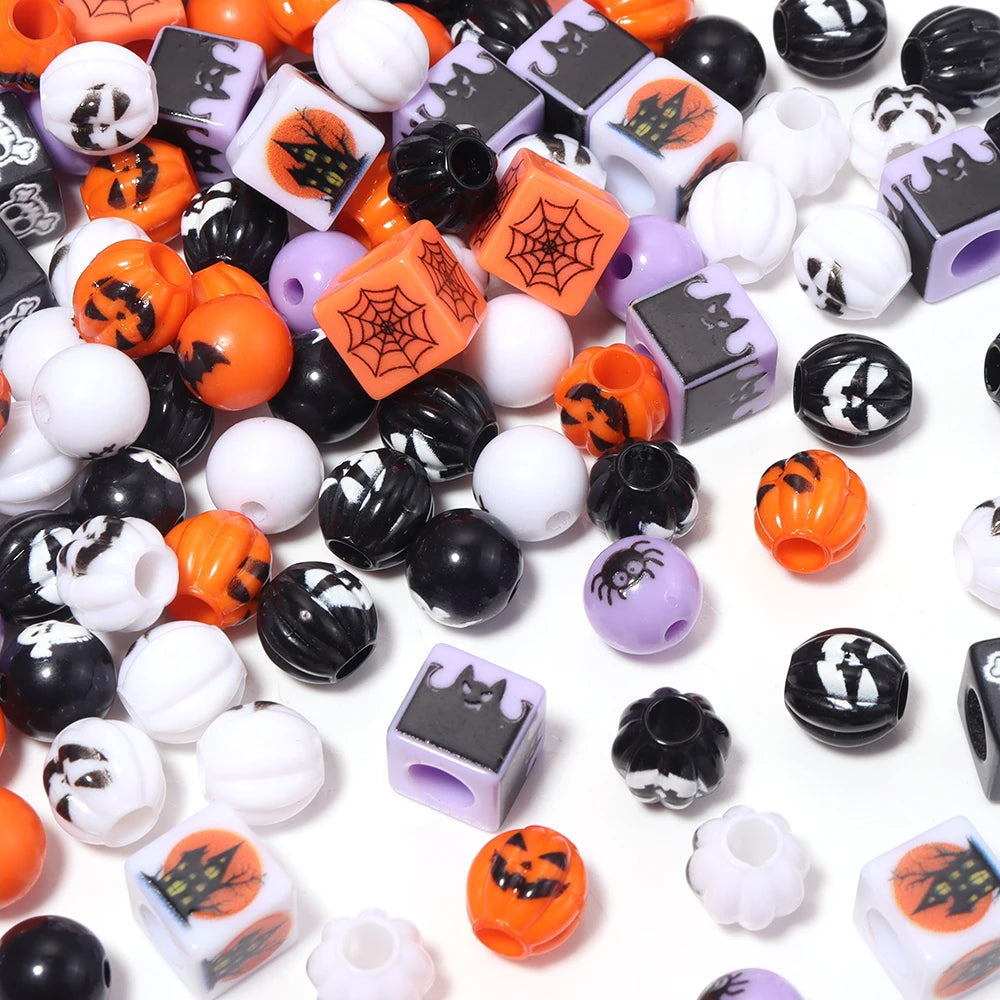 A collection of black, orange, purple, and white acrylic beads with Halloween designs used for DIY jewelry and crafts.