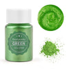 A glass jar of green pearl powder next to a swirling green liquid and a pile of green powder.