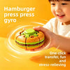 A child holds a green and orange burger-shaped press gyro toy, demonstrating its one-click transfer and stress-relieving feat