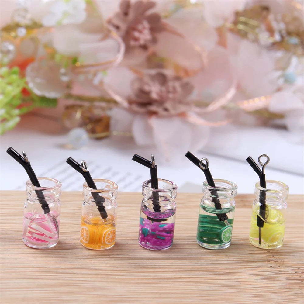 A collection of twenty assorted resin fruit and drink charms in various colors displayed in small glass jars.