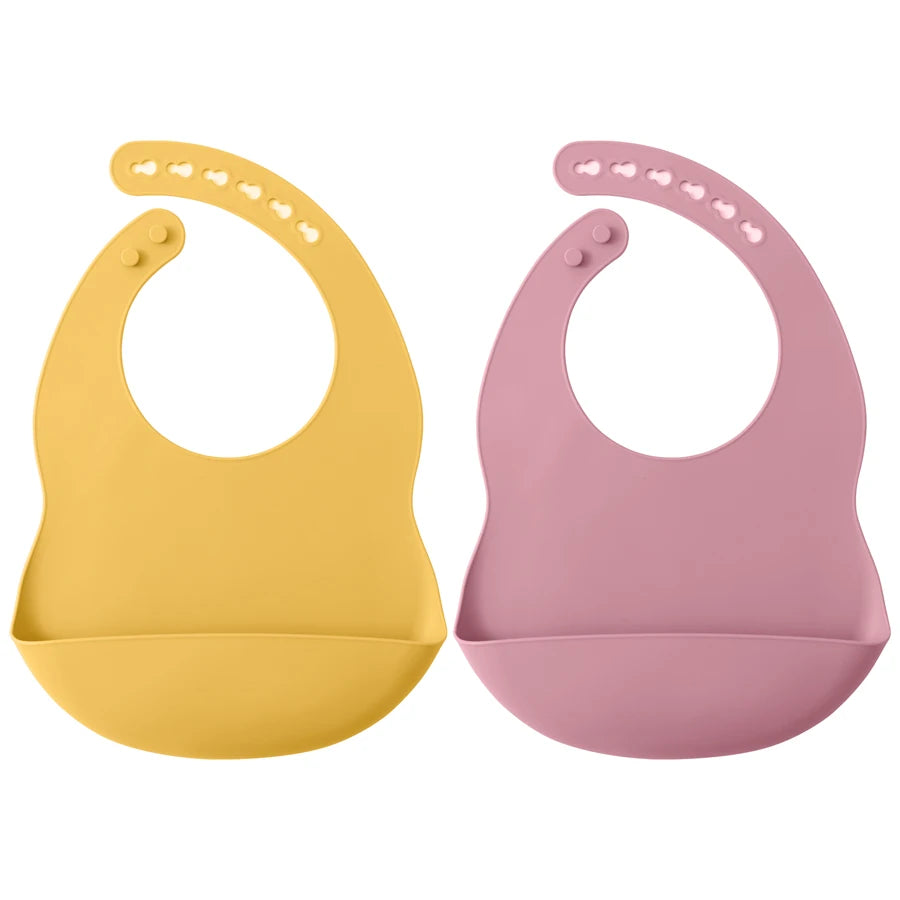 A pair of silicone baby bibs, one yellow and one pink, with adjustable necks.