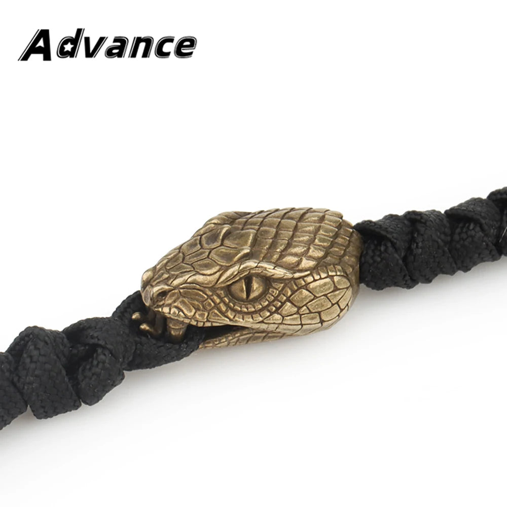 Brass snake head charm attached to a black paracord lanyard bead