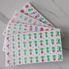A stack of pearl pink acrylic American Mahjong tiles in four layers, showing various colored and patterned tiles.