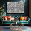 A black and white jigsaw puzzle displayed on a wall above a teal sofa and coffee table.