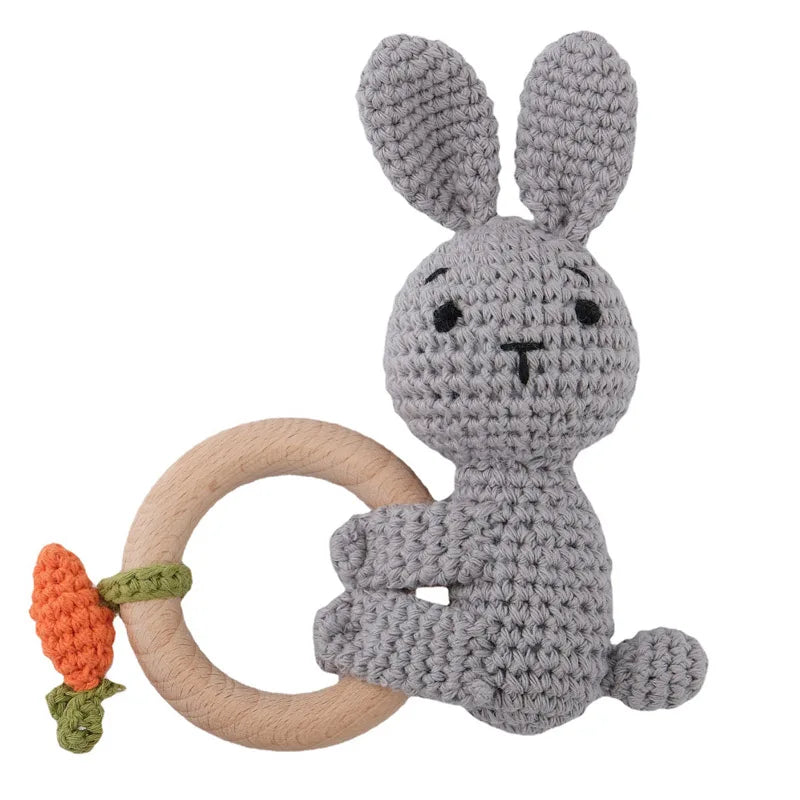 A gray knitted rabbit rattle and teether ring made of wood