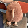 A fluffy brown kiwi bird plush toy sitting on a chair.