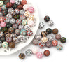A collection of colorful printed silicone beads in various patterns and colors arranged on a white platter.