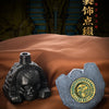 A handcrafted Aztec death whistle with a skull design and gold accents resting on brown fabric.