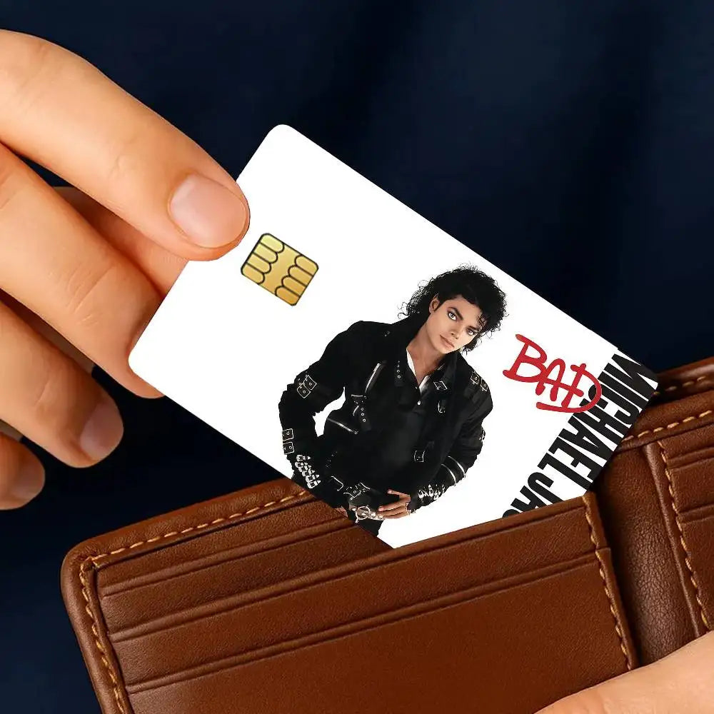 A hand holds a white card with a black and red design featuring Michael Jackson's silhouette and a gold fist symbol.