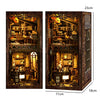 A dark wooden bookshelf insert designed as a book nook with warm LED lighting and detailed miniature scenes.