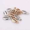 A collection of 50 plastic seashell charms in silver and gold tones for jewelry making.