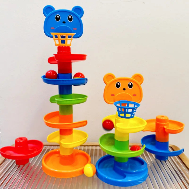 A colorful interactive ball tower featuring an orange bear top, stacked rings, and blue rolling balls on a glass surface.
