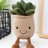 A cute plush stuffed toy resembling a tulip succulent with green leaves and brown stems.