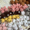 A collection of handcrafted crochet animal keychains including rabbits, chicks, cats, and dogs in various pastel and earthy t
