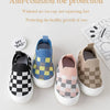 A collection of four knitted toddler shoes featuring various plaid patterns and toe protection designs.