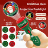 A hand holds a green projection flashlight with a Christmas theme, showing various patterns and an image of Santa.