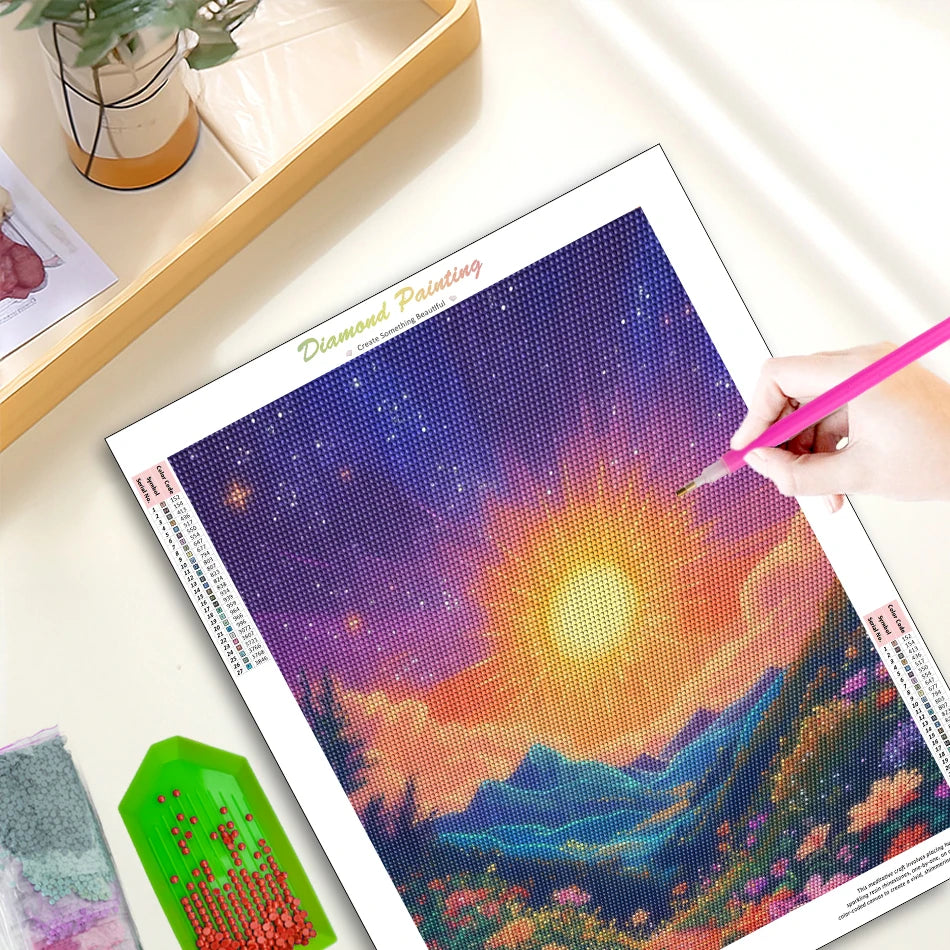 A diamond painting kit featuring a vibrant sunrise landscape with mountains and colorful sky