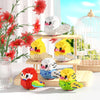 A set of colorful parrot micro building blocks featuring yellow, white, and red birds in various poses.