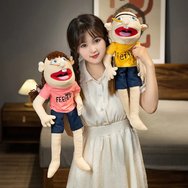 A young woman holds two realistic plush hand puppets, one resembling a character with brown hair and another with blonde hair