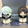 Two chibi figurines of Fatui Harbingers with light blue hair and dark hair, displayed in their blind box packaging.