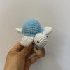 A handmade wooden baby rattle and teether ring shaped like an otter, featuring blue and white textured parts.