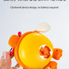 A hand holds a yellow wind-up swimming bath toy with orange accents, designed to twist and swim forward.