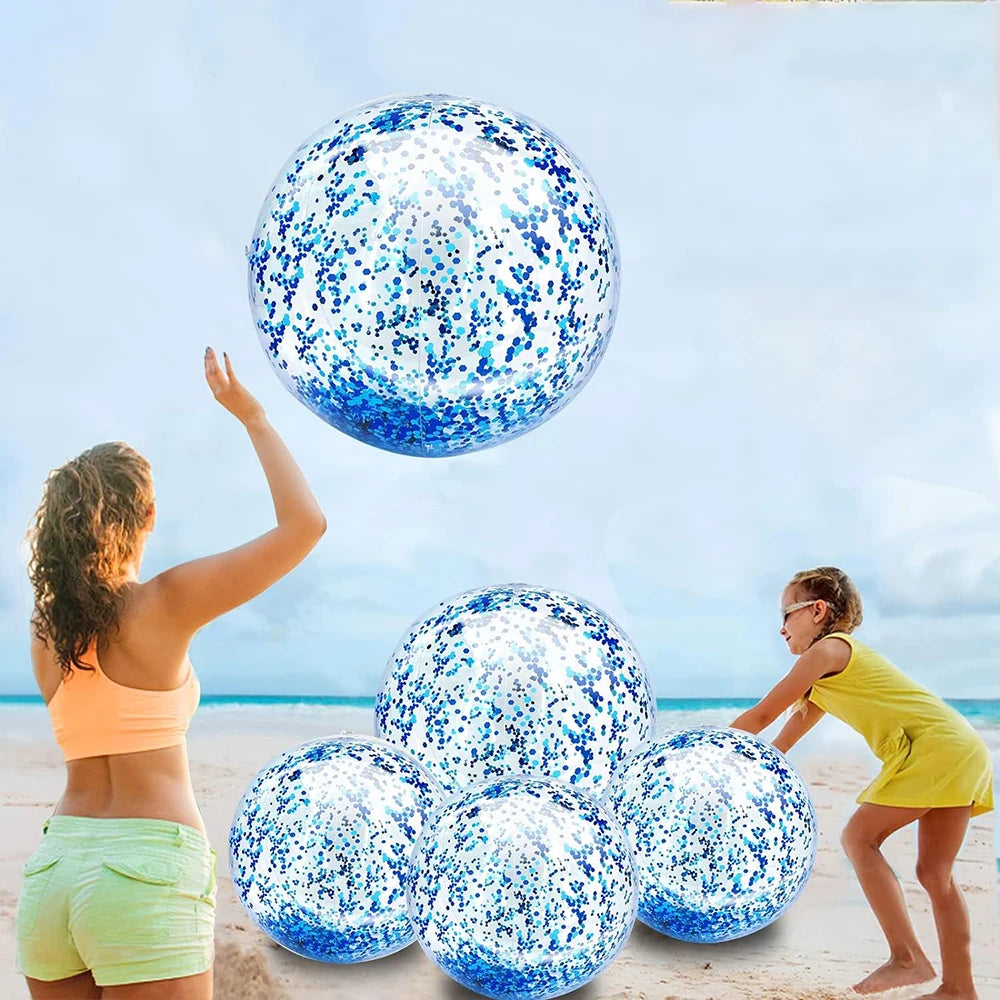 A woman is tossing a blue sequined inflatable beach ball high in the air against a bright sky.