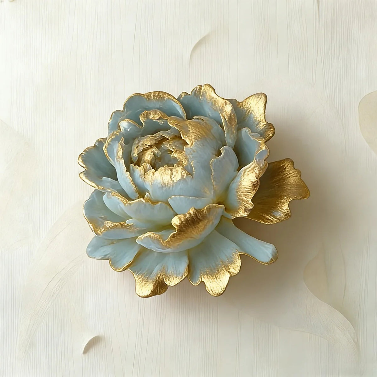 A light blue silicone flower mold with gold accents resting on a white surface.