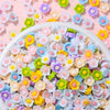 A bowl filled with assorted pastel colored resin flatbacks for DIY crafts and jewelry making