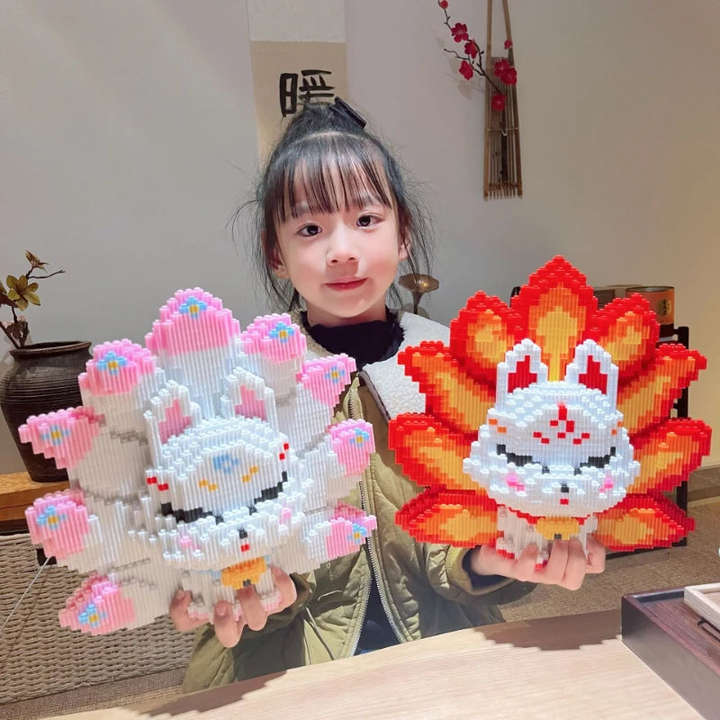 A woman holds a finished Nine-Tailed Fox building block set featuring white and pink pieces against a light background.
