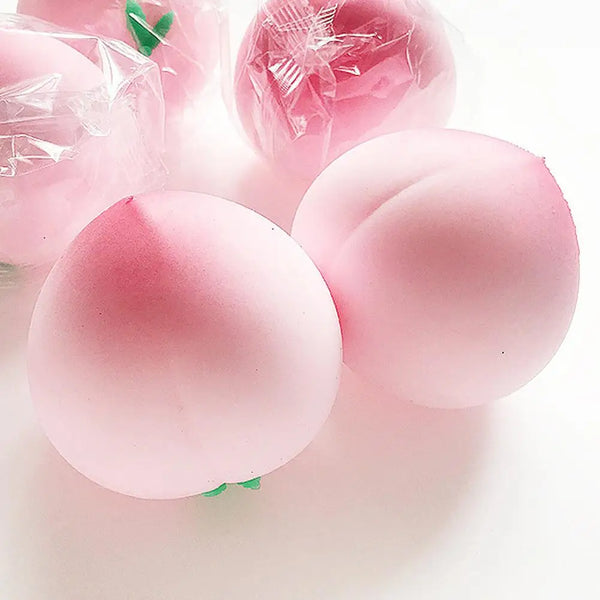 A close-up of pink peach squishy stress relief toys in clear plastic packaging.