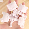 A hand holds a collection of 12 customizable white bobble head pet figures for a DIY kit.