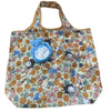 A soft stuffed animal of a pygmy hippo in blue and white, displayed on a floral patterned fabric bag.