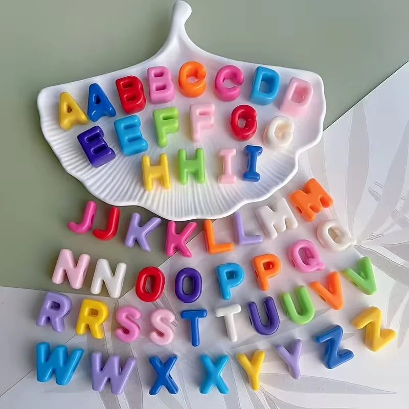 A collection of colorful acrylic letter beads in uppercase and lowercase alphabets arranged on a white surface.