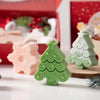 A set of festive silicone Christmas tree and snowflake cookie and candle molds in green and pink colors.