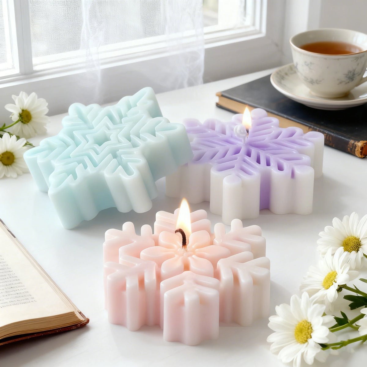 Pink and purple snowflake silicone molds for candles, soap, and wax melts displayed on a white surface.
