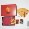 A red box and a pink folder for the Secret Hitler card game, featuring a skull logo and character cards.