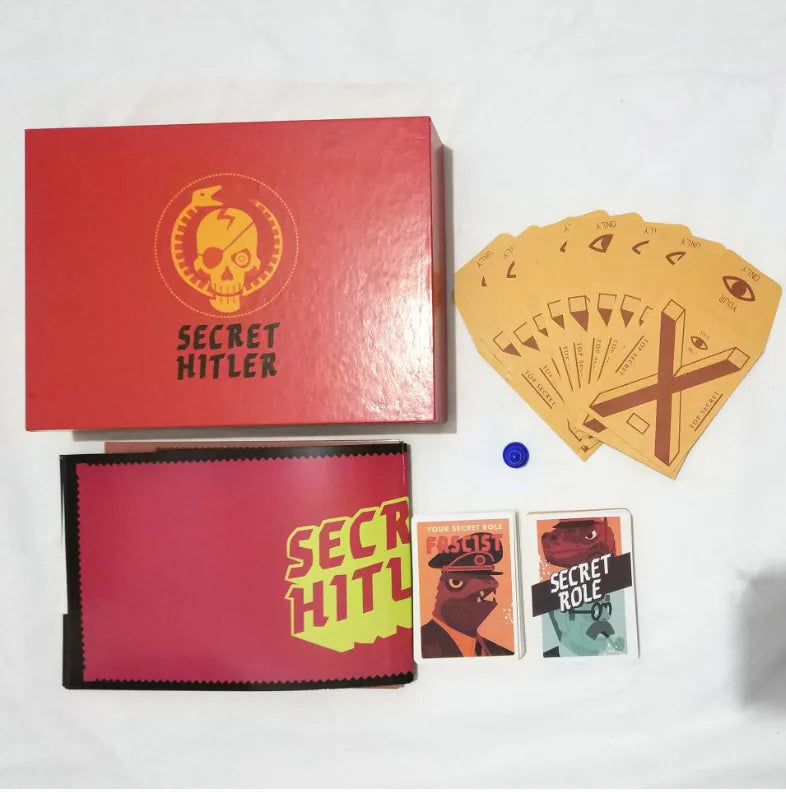 A red box and a pink folder for the Secret Hitler card game, featuring a skull logo and character cards.