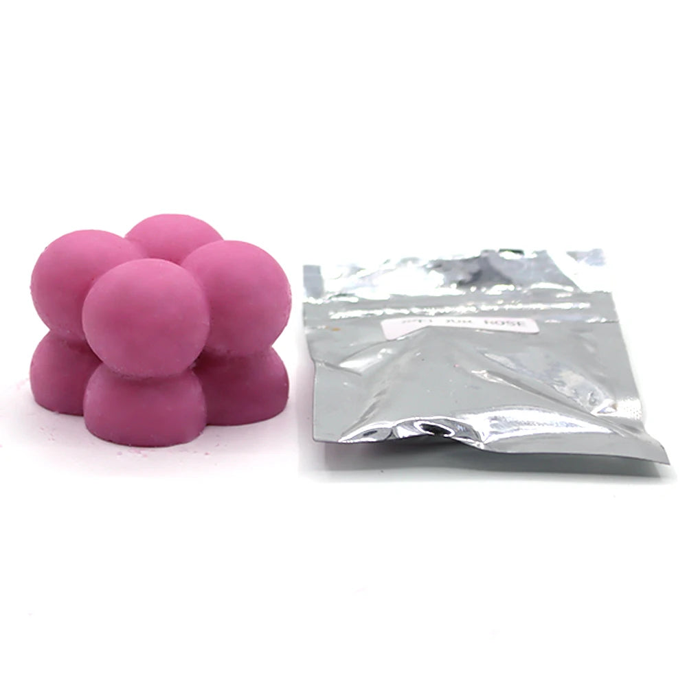 A pile of pink candle dye chips for soy wax, beeswax, and paraffin wax.