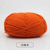 A ball of bright orange pre-dyed milk cotton yarn used for knitting and crochet.