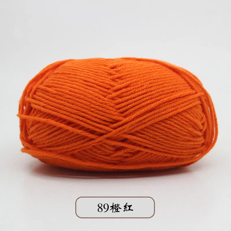 A ball of bright orange pre-dyed milk cotton yarn used for knitting and crochet.