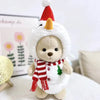 A fluffy teddy bear plush wearing a white dress and a red and white striped scarf with a pointed hat.